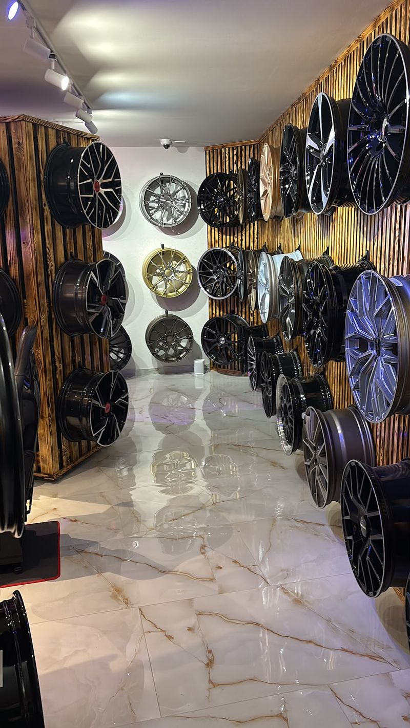 Gang im Showroom mit Felgen an Holz- und Wabenwand